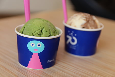 two ice cream on blue containers on brown wooden table thumbnail