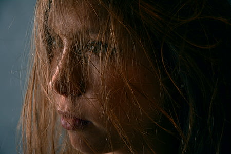 close view of brown-haired woman with messy hair thumbnail