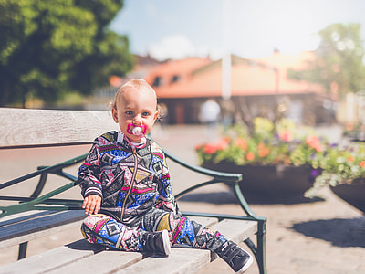 toddler sitting on gray wooden bench thumbnail