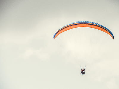 person parachuting under gray sky thumbnail