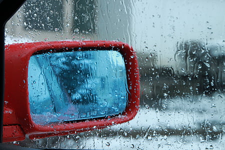 wet vehicle window with red side mirror on outside thumbnail