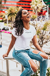 woman wearing distressed jeans sitting on rails thumbnail