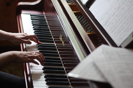 person playing upright piano thumbnail