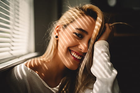 woman smiling near window with blinders thumbnail