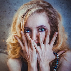 close-up photo of woman covering face thumbnail