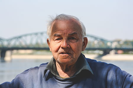 man wearing blue sweater with bridge background thumbnail