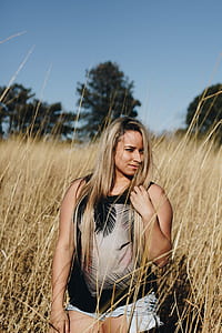 selective focus photography of woman standing near brown grasses thumbnail