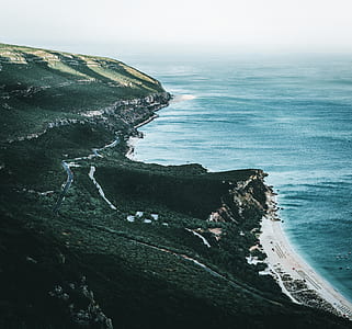 aerial view of mountain near body of water thumbnail