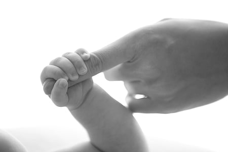 baby holding index finger thumbnail