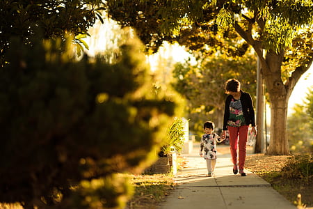 woman holding baby walking on street thumbnail
