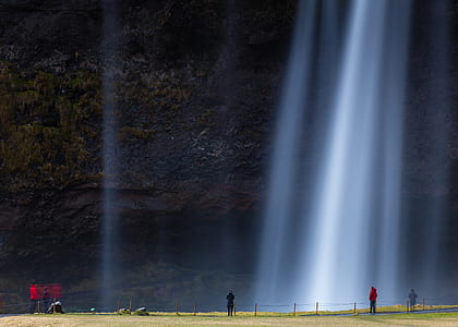 people standing near waterfalls at daytime thumbnail
