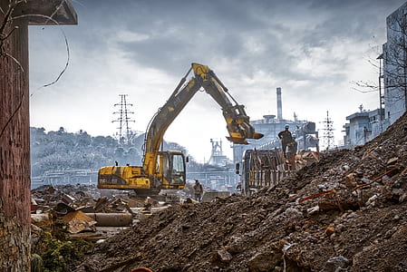 people in construction beside yellow excavator thumbnail
