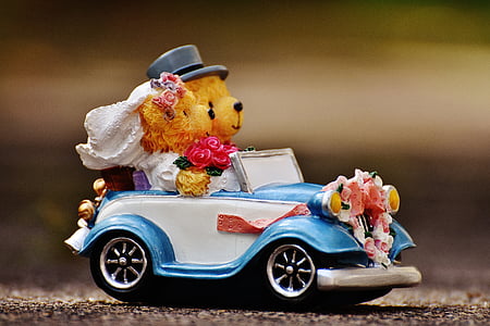 selective focus photography of bride and groom bear riding car figurine thumbnail
