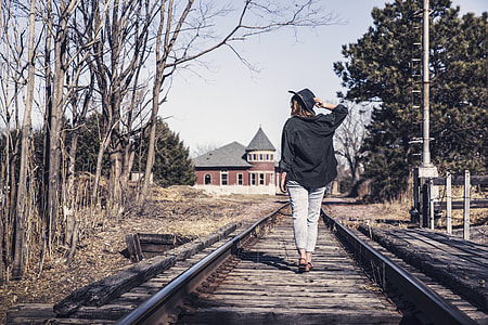 woman wearing black jacket walking on railway thumbnail