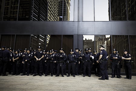 group of police officers standing near concrete building thumbnail