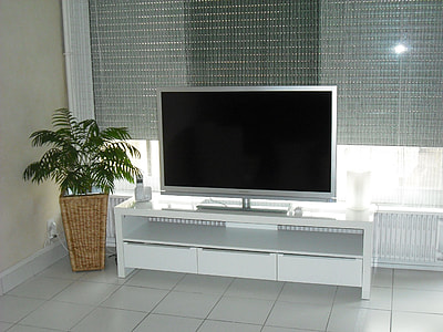 turned-off flat screen television on top of TV stand thumbnail