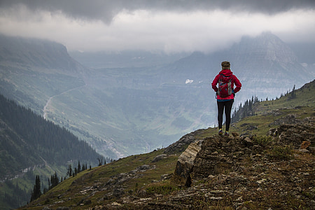person wearing red jacket standing at mountain cliff thumbnail