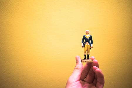 person holding man in black coat mini figure thumbnail
