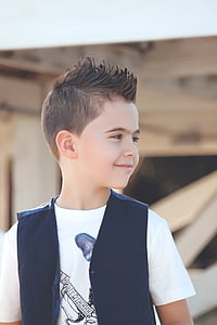 boy in black vest smiling on selective focus photo thumbnail