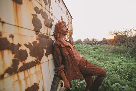 Man Wearing Brown Button-up Jacket and Pants Leaning on Wall thumbnail