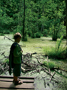 boy standing near twigs thumbnail