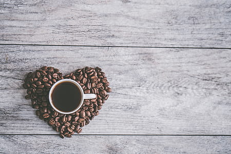 White Ceramic Mug Filled With Brown Liquid on Heart-shaped Coffee Beans thumbnail
