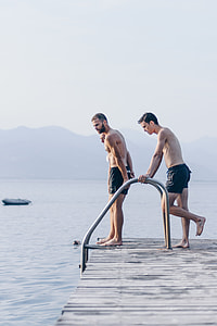 people standing on dock under cloudy sky during daytime thumbnail