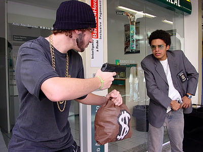 man holding money bag and gun pointing man wearing black blazer thumbnail