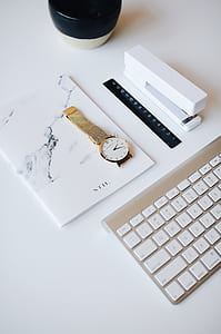 round gold-colored analog watch on book thumbnail