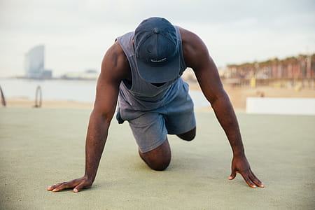 A young African man wearing causals stretching outdoors thumbnail