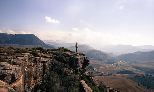 landscape photography of man standing at the cliff thumbnail