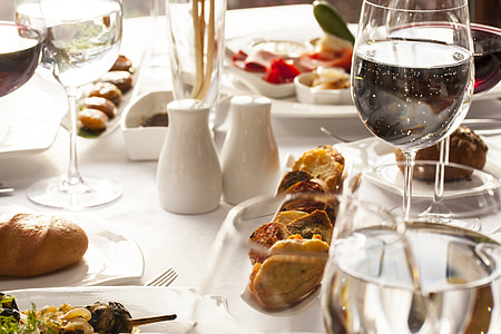 two white condiment shakers beside long-stem wine glasses on table thumbnail