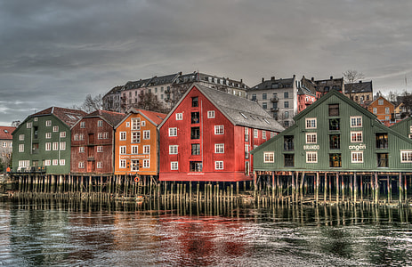 assorted houses near small body of water under grey sky thumbnail