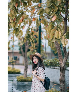 Smiling Woman Wearing Brown Hat and White Floral Elbow-sleeved Dress thumbnail