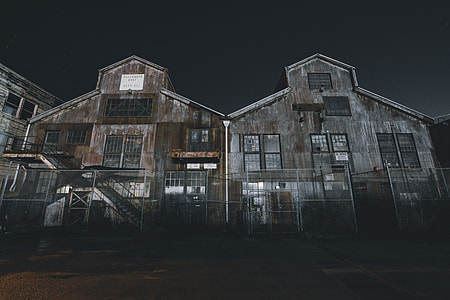 two rusted gray wooden houses under gray sky at night time thumbnail