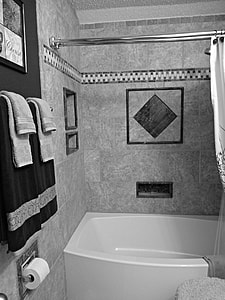 two towels hanged on rod near empty white bathtub thumbnail