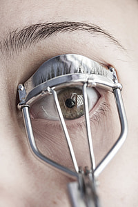 person folding eyelashes using silver eyelash curler thumbnail