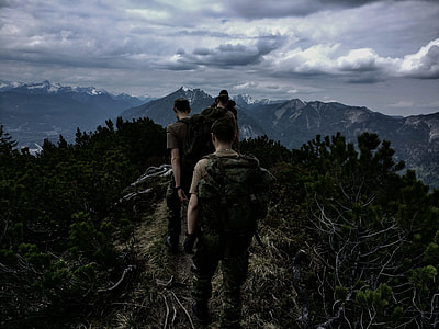 people walking on top of mountain under cloudy sky thumbnail