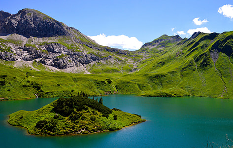 landscape photography of body of water and mountains during daytime thumbnail