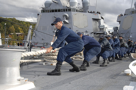 group of men wearing blue uniform pulling white rope thumbnail