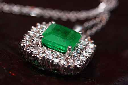 clear and green stone pendant against black background thumbnail