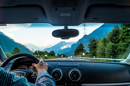 Man driving a car on road in the mountains of Switzerland thumbnail