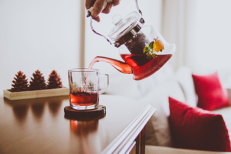person pouring red tea on a clear glass mug thumbnail