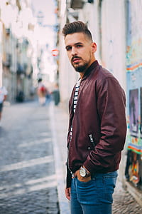 man in brown leather jacket hands on jeans pocket thumbnail