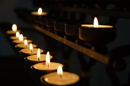 lighted tealight candle on black metal rack thumbnail