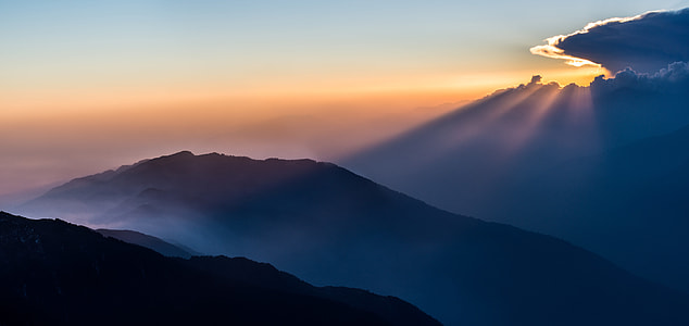 aerial photography of mountain under cloudy sky at golden hour thumbnail