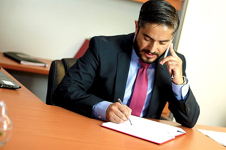 man with black suit jacket holding pen thumbnail