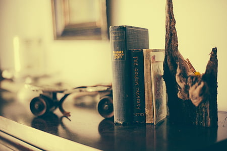 three black and brown books on table thumbnail