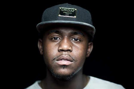 man in black fitted cap; white crew neck shirt thumbnail