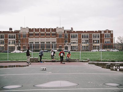 five boys riding skateboards outdoor during cloudy day thumbnail